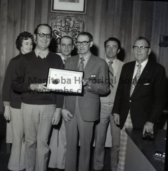 (Schram) April 29th, 1974 CURLING JIM WISHART RECIEVES CITY OF PORTAGE LA PRAIRIE DISTINGUISHED CITIZENS’ RECOGNITION RECIEVES AWARD J. W. “Jim” Wishart, centre, was presented a Distinguished Citizen Award Monday prior to city council meeting, Mr. Wishart last Thursday was elected president of the Manitoba Curling Association, marking the first time that an out-of-Winnipeg resident has headed the MCA in its 88-year history. Alderman Gary Cobbe is making the presentation while Mayor H. L. Henderson looks on. Consensus among council members was that the singular honor conferred on Mr. Wishart was well deserved for his efforts on behalf of curling over a span of more than 35 years, both locally and provincially. 1706b.jpg